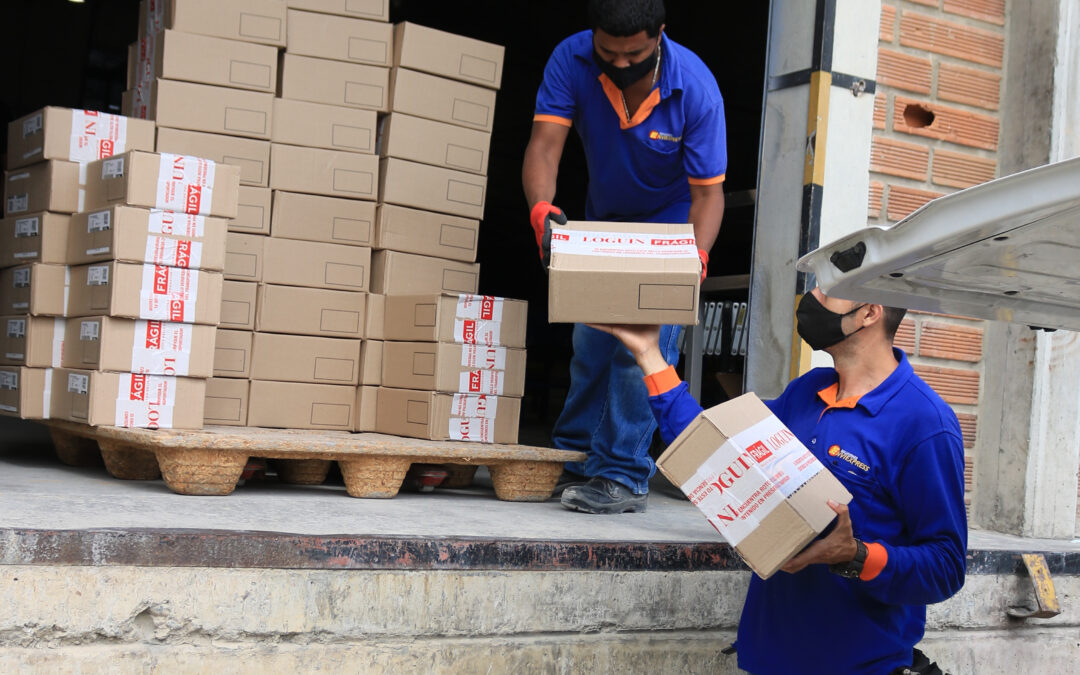 Operarios de EnviExpress cargando cajas de devoluciones en el muelle para su retorno al generador